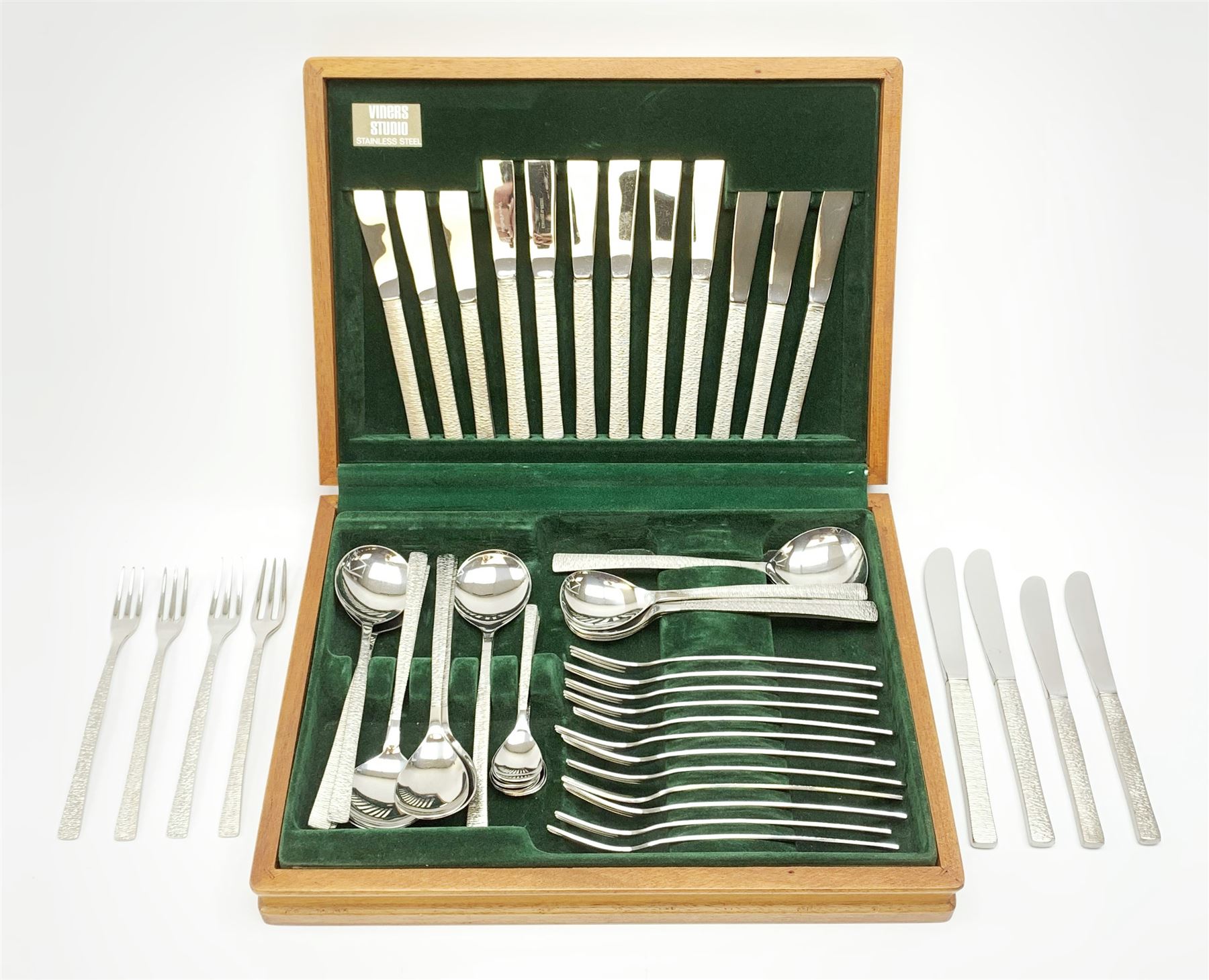 A canteen of bark effect stainless steel cutlery by Gerald Benney for Viners Studio, in a teak case. 