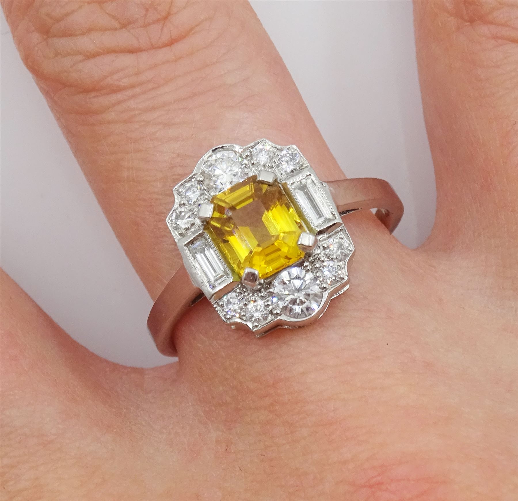 Platinum emerald cut yellow sapphire, baguette and round brilliant cut diamond cluster ring, stamped Plat, sapphire 1.30 carat, total diamond weight 0.55 carat, with World Gemological Institute Report