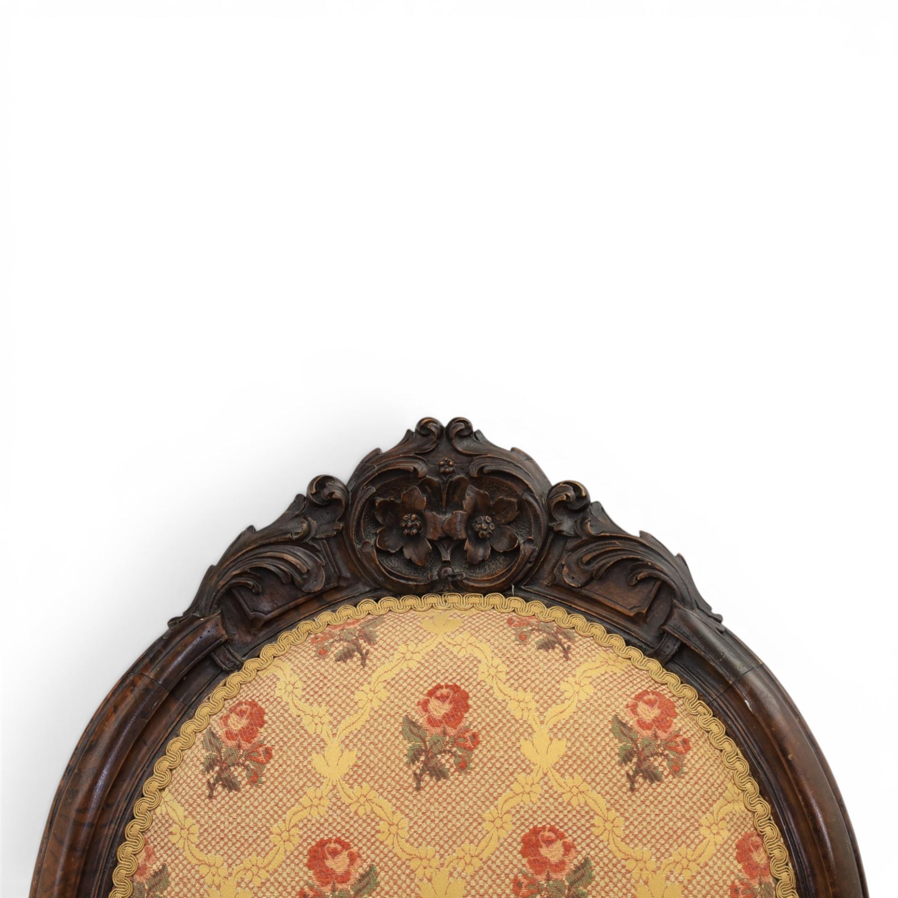 Victorian mahogany open armchair, oval stuff-over back with floral upholstery, moulded and foliate carved frame with pierced crest, padded open arms with scroll terminals, serpentine seat rail on cabriole supports
