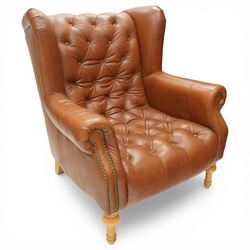 Alexander James design fully tan leather chair, with full button back seat and back, with scrolled arms with studded trim, raised on light stained turned supports