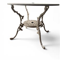 Victorian design cast aluminium garden table and twin armchairs featuring a pierced floral wreath splat, over a stylised scrolling acanthus leaf seat, including parasol