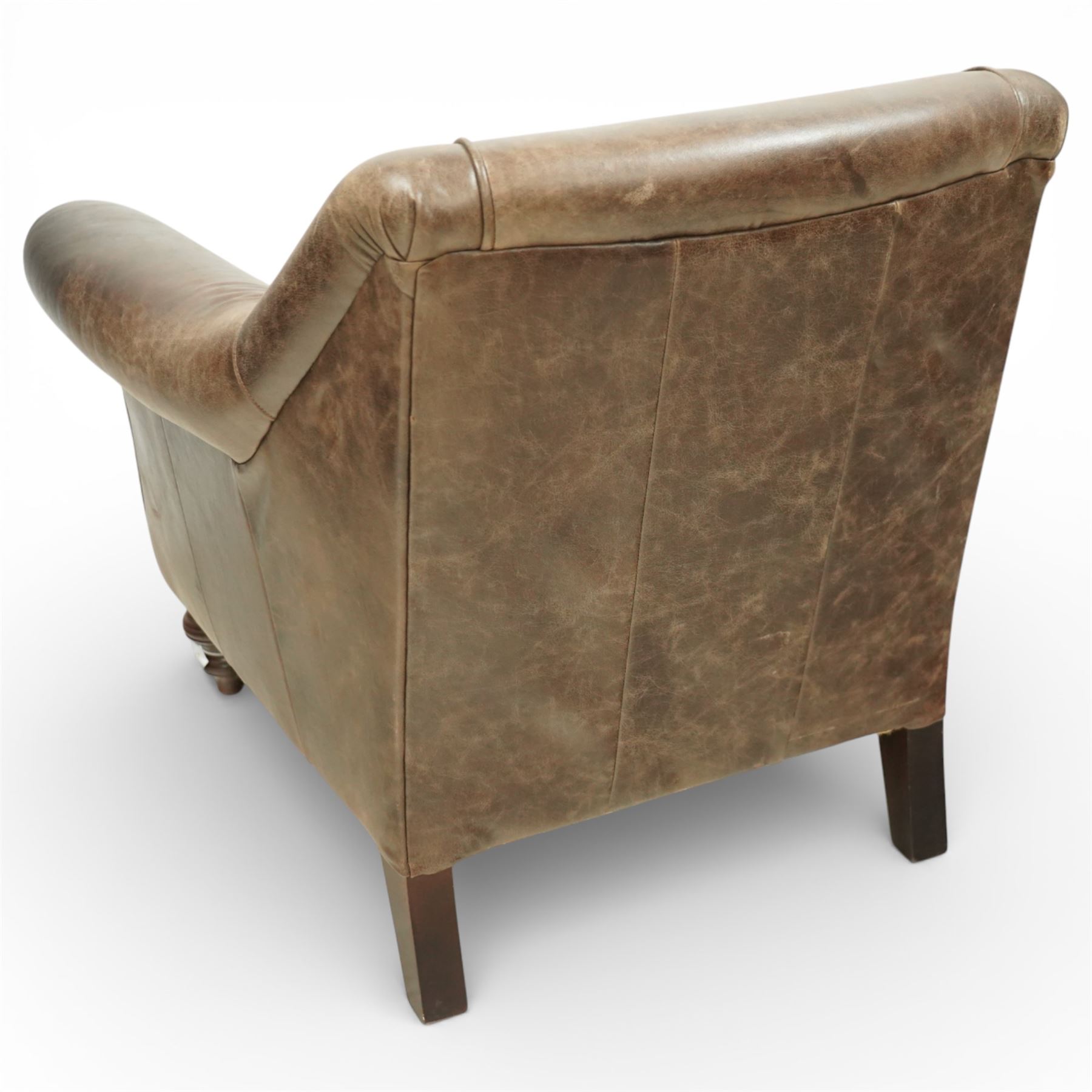 Tetrad - late 20th century leather armchair, upholstered in brown leather with a gently curved back and rolled arms, loose seat cushion over a padded base, raised on turned wooden feet