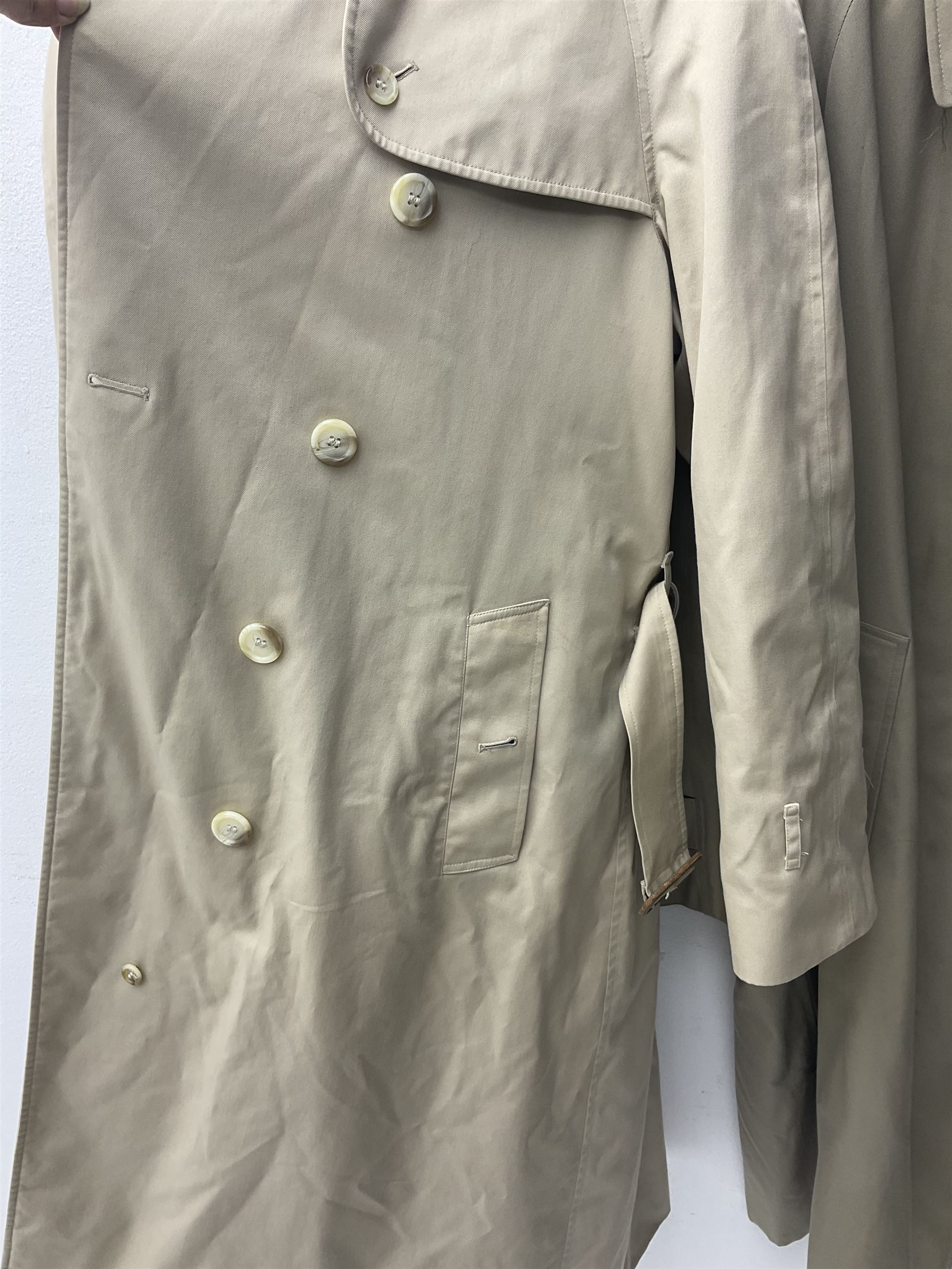 Ladies Burberry double breasted trench coat, with belt and detachable woollen gilet, in traditional cream colour with Burberry check lining, together with a gentlemans Burberry single breasted trench coat, both L112cm