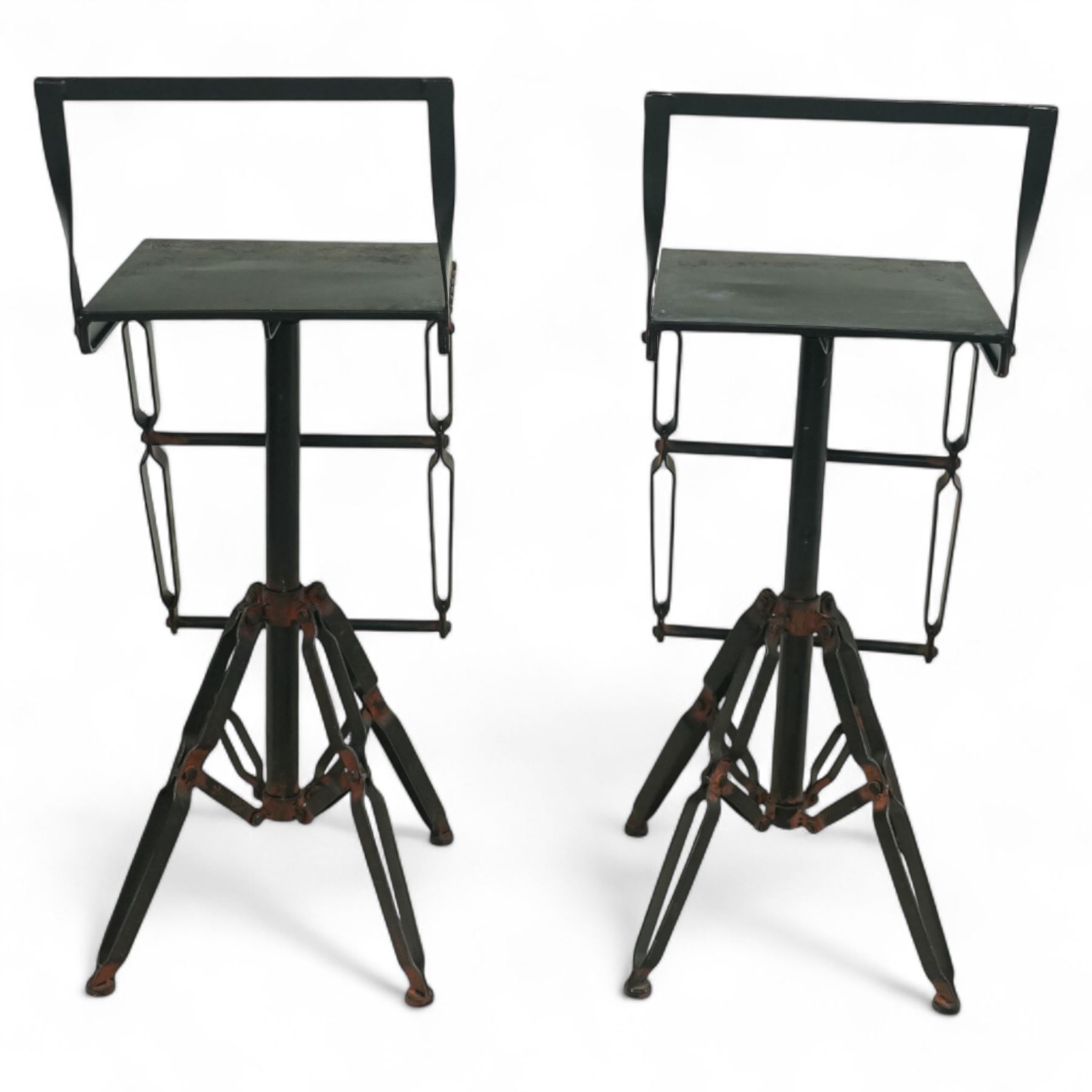 Pair of 20th century brutalist industrial metal swivel bar stools, sheet seats with strap backrests with bolted design to the sides, raised on quadripod bases with angular strut supports, the seats height-adjustable and swivelling