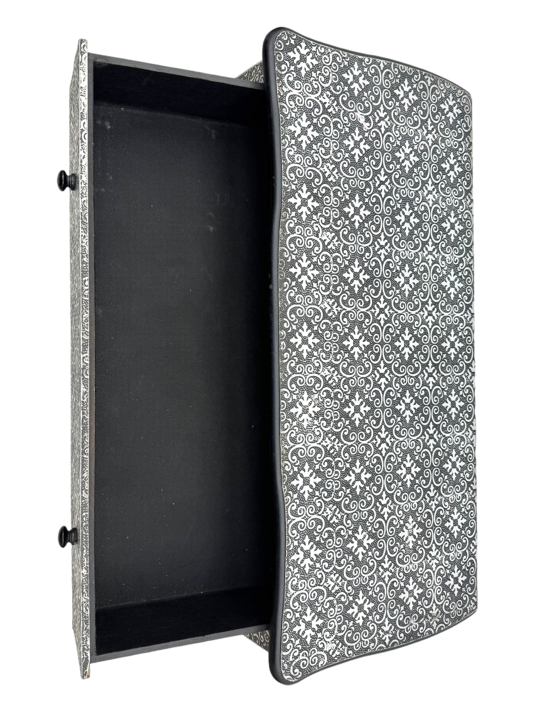 Contemporary black lacquered metal-clad chest, embossed with silver floral scrollwork, shaped rectangular top over three drawers, on cabriole supports (W89cm, D40cm, H79cm); matching two drawer chest (W68cm, D35cm, H67cm)