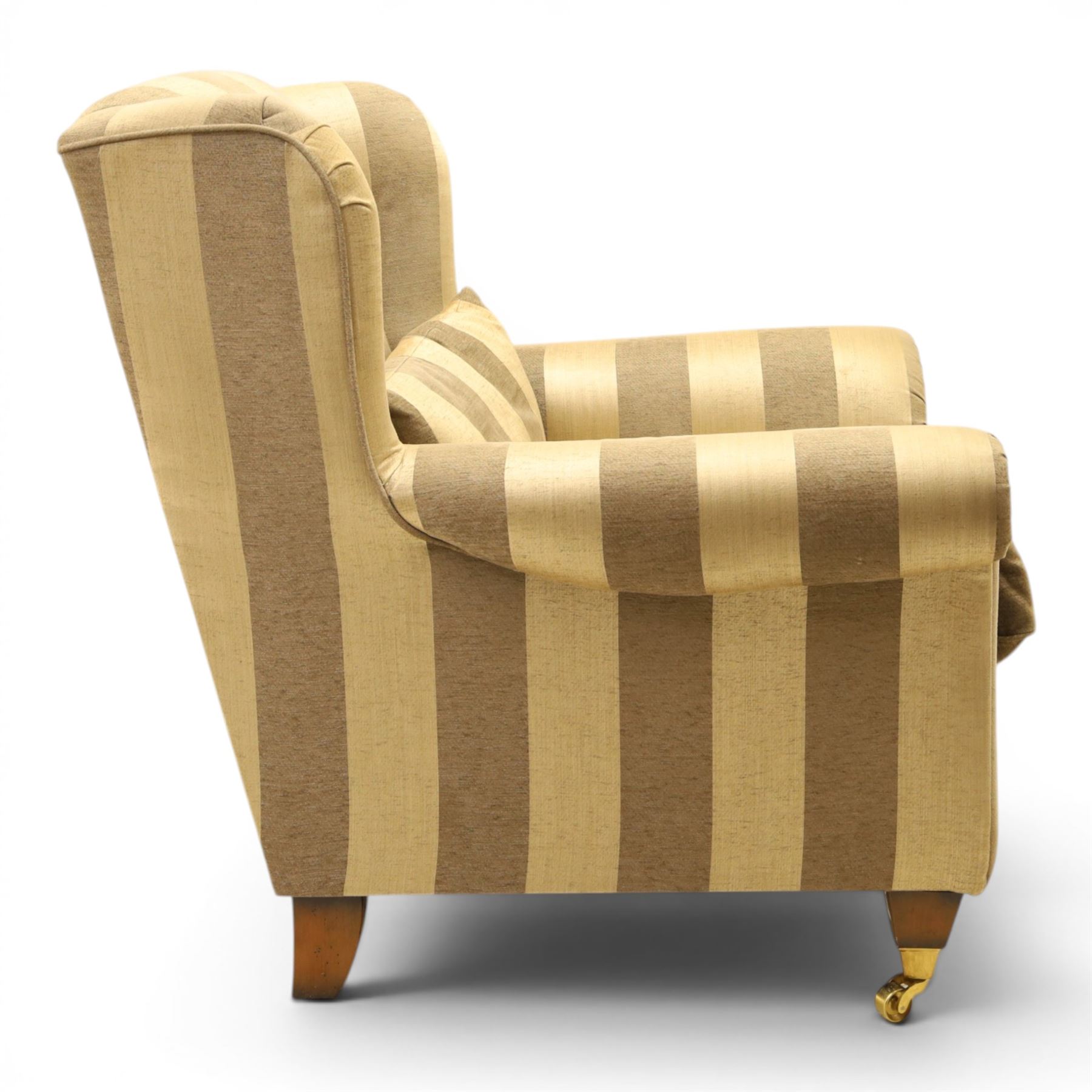 Alstons - 'Ixworth' armchair, upholstered in striped fabric, with loose seat cushions and scrolled arms, brass front castors