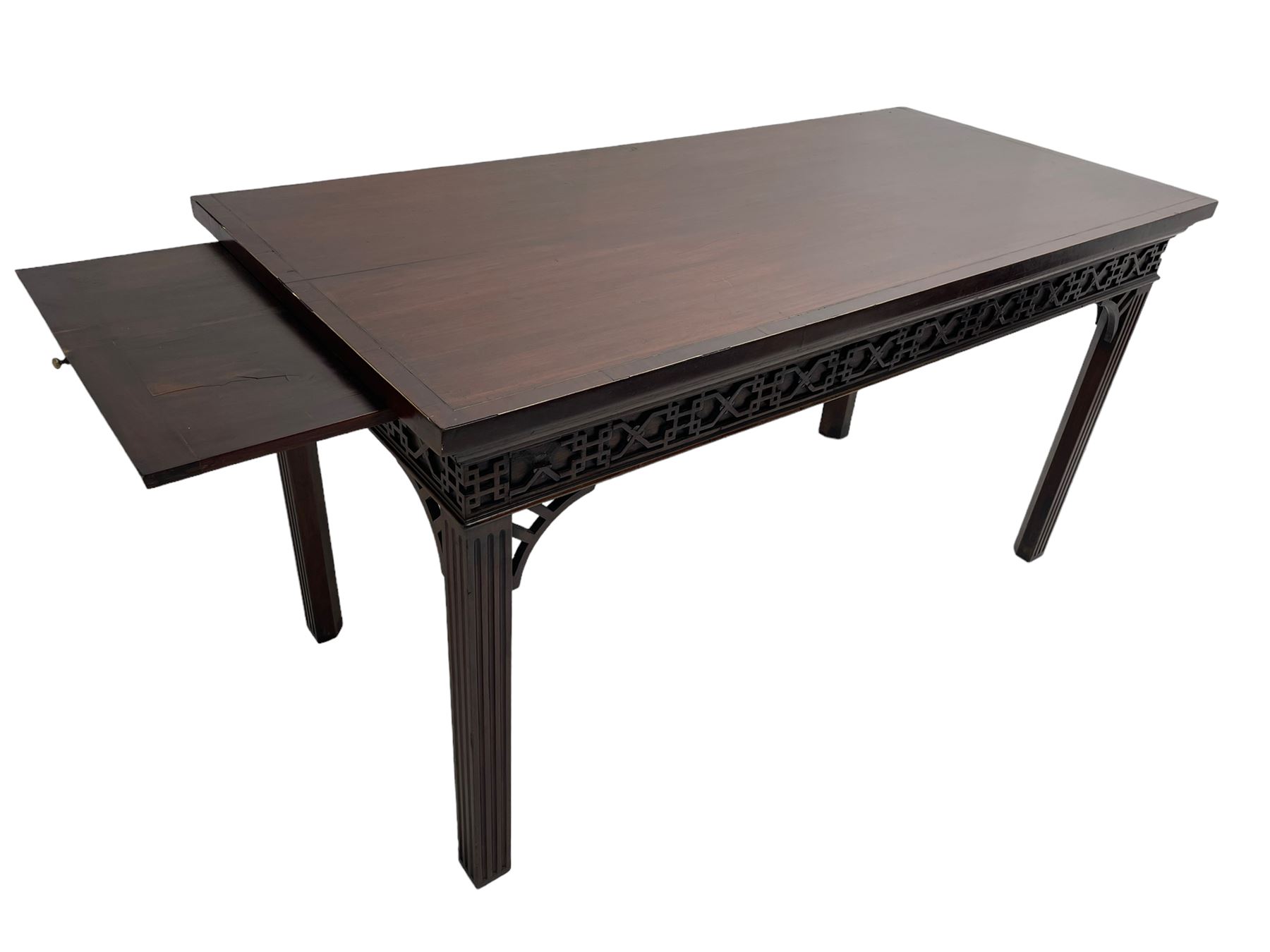 In the manner of Thomas Chippendale - early 19th century mahogany serving table, rectangular crossbanded top with boxwood stringing, the frieze with upper moulding over applied geometric fretwork, the left-hand side fitted with slide, on fluted square supports with inner chamfer 