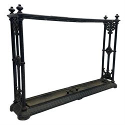 Coalbrookdale design - late 19th century black finish cast iron stick stand, the rectangular top set with one row of nine circular divisions, cluster column upright supports united by scrolled decoration, on moulded skirted base with two lift-out drip-trays, with registration lozenge to underneath 
