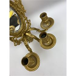 Pair of 19th century ormolu three branch wall sconces, the oval bevelled edge mirror backs within frame flanked and surmounted by putti, supporting three scrolling branches above female mask terminals, H32cm 