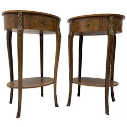 Pair of early 20th century French walnut bedside stands, oval bookmatched and cross-banded top fitted with single drawer, raised on cabriole supports united by undertier, decorated with floral gilt metal mounts