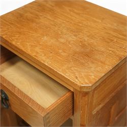 Beaverman - pair of oak bedside cabinets, each with plain rectangular top over single drawer and cupboard below with fielded panels and wrought iron hardware, with signature carved beaver, by the workshop of Colin Almack, Thirsk