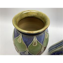 Two Royal Doulton stoneware vases, the first example with tubelined floral decoration, the second with Art Nouveau decoration, together Doulton Lambeth vase of flattened form with foliate decoration on a green ground, all with impressed mark beneath, tallest example H26cm