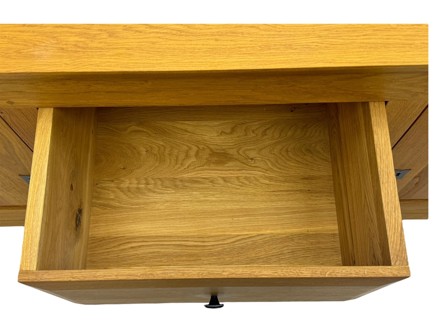 Contemporary light oak sideboard, chamfered rectangular top over two central bevel-edged drawers, flanked by two recessed panelled cupboards enclosing shelving, on square stile supports