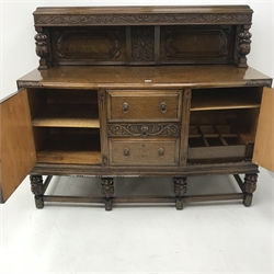 Early 20th century oak sideboard, raised back with carved cup and cover supports above three drawers flanked by two cupboards, carved supports joined by stretchers, W152cm, H133cm, D61cm