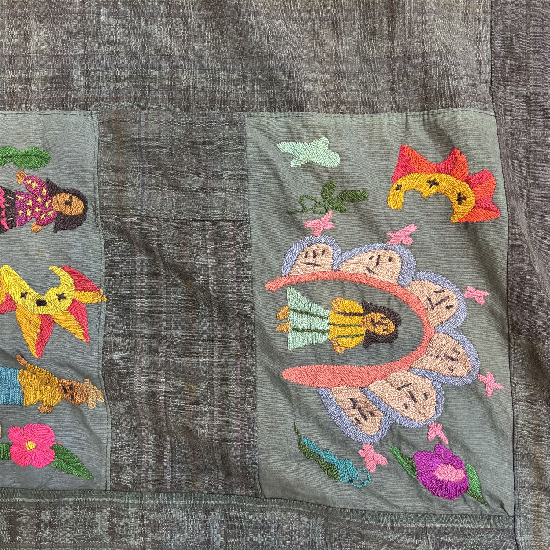 Guatemalan hand stitched wall hanging panel, naively embroidered with figures, animals, and flowers in a bright pallet, upon a dark green ground, approximately H230cm W115cm