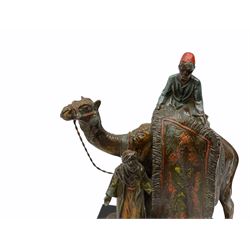 After Franz Bergmann, a cold painted spelter table lighter modelled as a figure upon a camel table with two rug traders, raised on faceted black glass base, H19.5cm 