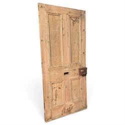 Victorian stripped pine four-panel door, the raised fielded panels within carved foliate and moulded surrounds, with iron lock and fittings and brass knob handle