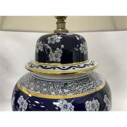 Pair of blue and white table lamps, each of baluster form, decorated with prunus blossom, within stylised borders, raised upon circular gilt base, excluding fittings H48cm