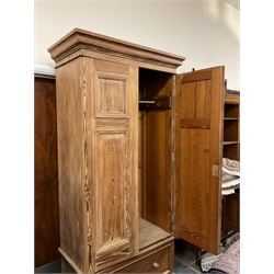Victorian pitch pine double wardrobe, projecting moulded cornice over two panelled doors, the interior fitted with hanging rail and hooks, single drawer to base