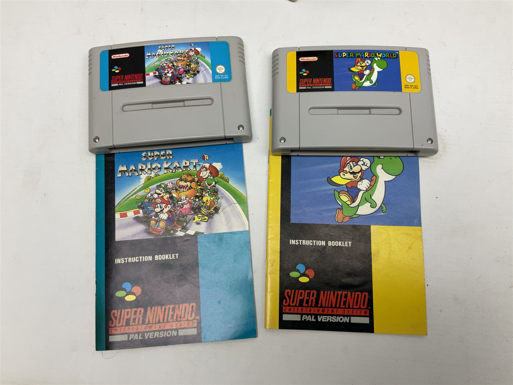 Two Super Nintendo Entertainment System (PAL) controllers, accessories and games. Super NES Game Commander with original box and instruction booklet, Super NES Nintendo Scope (1992) transmitter gun, receiver, Super NES Nintendo Scope 6 game with original instruction booklets. Further games to include ‘The Legend of Zelda a Link to the Past’, ‘Super Mario World’, ‘Super Mario Kart’, ‘The Lawnmower Man’, and ‘Exhaust Heat’, all with original instruction booklets. ‘PowerMonger’ and Disney’s ‘Aladdin’ game cartridges only 
