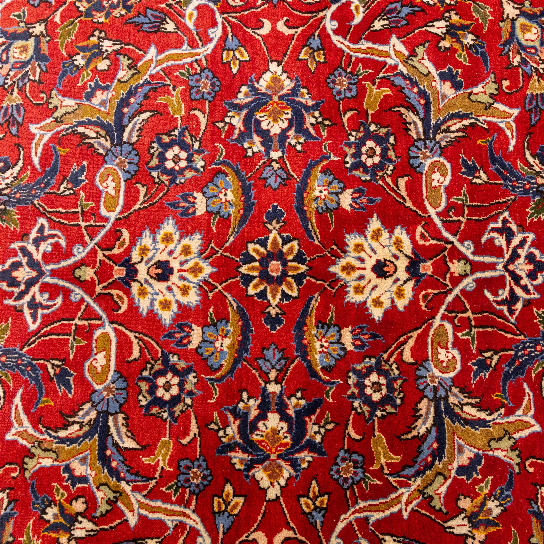 Central Persian Markazi Mahal hand-knotted carpet, terracotta red field, with an all-over scrolling vine design issuing with palmettes, rosettes, and serrated leaves, linked by ivory vinery, deep cobalt blue main border with floral ornamentation, flanked  by multiple guard stripes of repeating geometric motifs, with cotton fringe ends
