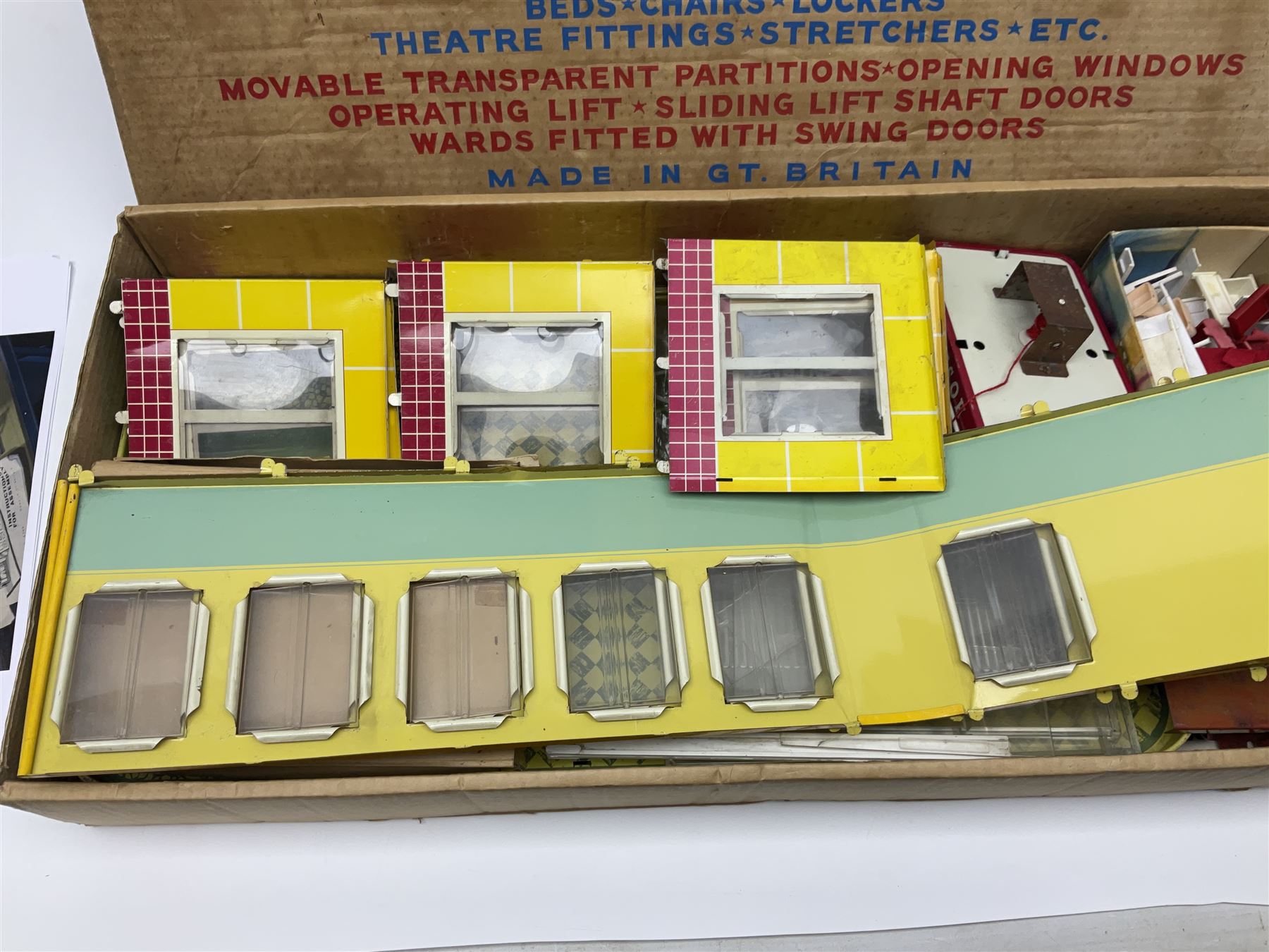Late 1950s/early 1960s Mettoy tin-plate Emergency Ward 10 hospital set from the TV series, including over twenty figures, over sixty pieces of hospital equipment, beds, chairs, lockers, theatre fittings, stretchers etc; building is complete with movable transparent partitions, operating lift with sliding lift shaft doors and opening windows; wards with fitted swing doors; tin-plate walls with lithographed detail in yellow with red and white tiled effect, cobbled base with ambulance casualties area and lift access; boxed with instructions
