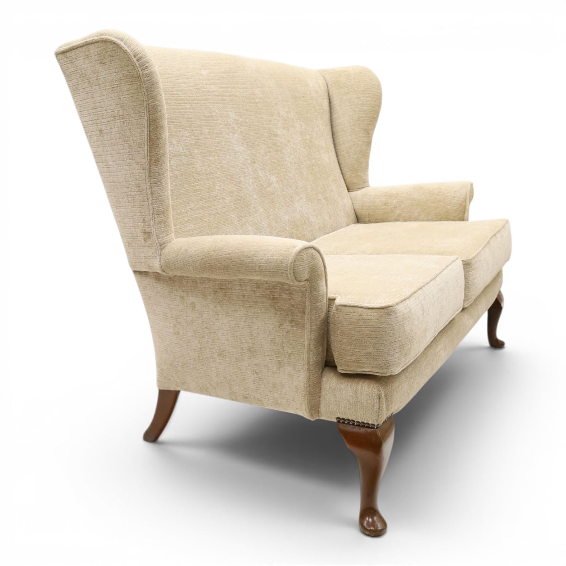 Parker Knoll - 'Hartley' lounge suite, comprising three wingback armchairs and two-seat settee, upholstered in cream fabric, shaped wing backs with scroll-over arms and loose seat cushions, on cabriole supports with pad feet wingbacks and settee

Armchairs: H 96cm, D 83cm, W 75cm