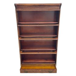 Early 20th century oak stacking library bookcase, four sections enclosed by hinged and sliding glazed doors, fitted with single drawer 