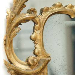 George III Chippendale design carved giltwood and gesso wall mirror, the impressive protruding pierced pediment decorated with flared acanthus leaves interspersed with flower heads and berries, over an arched outer-frame - the cresting comprised of C-scrolls carved with dripping icicle motifs, the uprights formed of scrolling acanthus with swags of grapevines and foliage, over a scrolled cartouche terminal, the inner-frame of architectural form with bell-flower details and a shaped cresting with scrolling acanthus leaves, all enclosing a central slightly bevelled rectangular mercury glass plate, surrounded by smaller plates