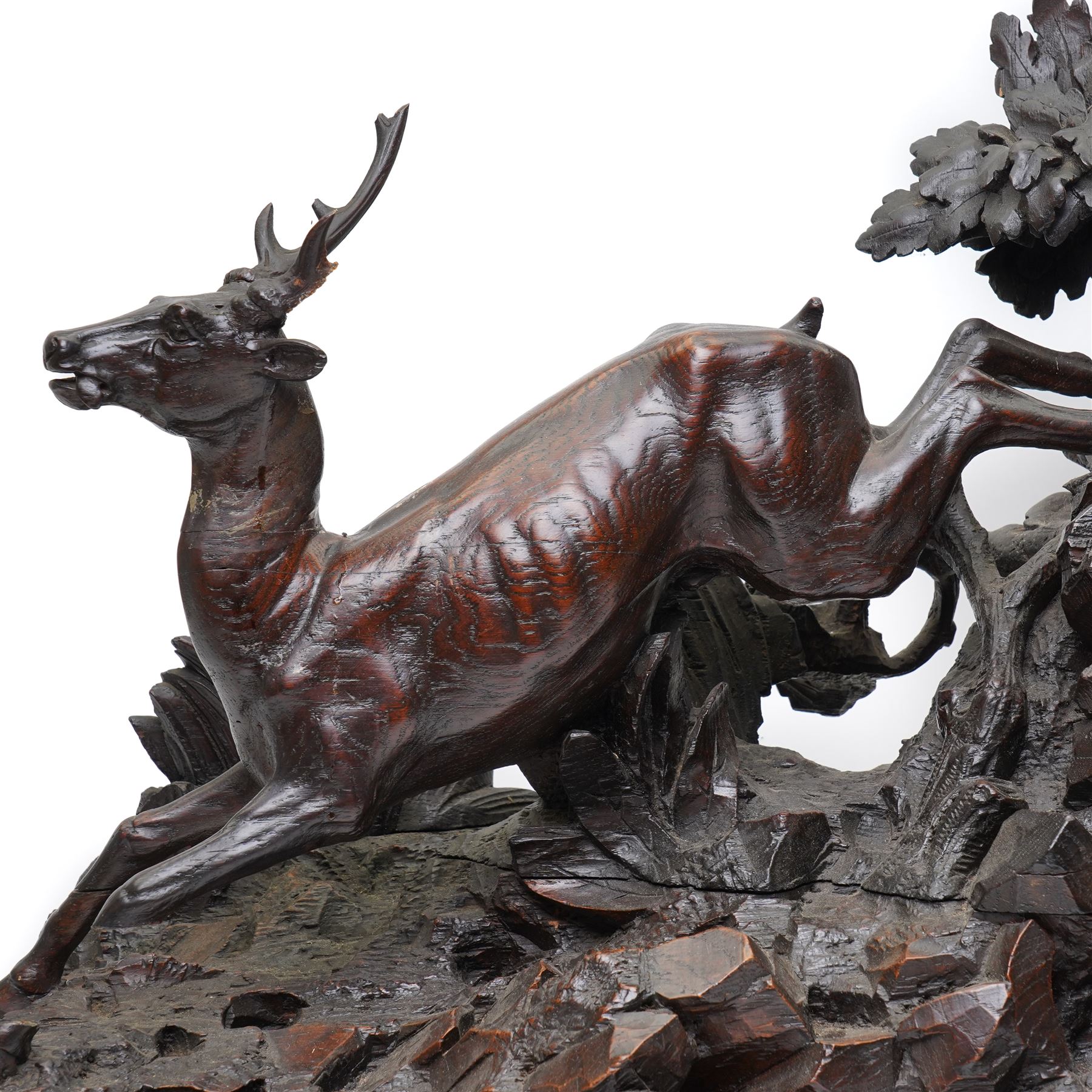 19th-century-8-day German Black Forest mantel clock c1880, with a carved oak case depicting a hunting scene with a stag pursued by hounds amidst rockwork and oak foliage, fitted with a French Parisian movement with a cast brass dial enclosed within a glazed brass bezel with a pendulum adjustment arbor, cartouche blue-on-white enamel  Roman numerals, engraved five minute Arabic's and contrasting steel Fleur-di-Lis hands, twin train going barrel movement with a recoil anchor escapement and countwheel strike. With pendulum.  