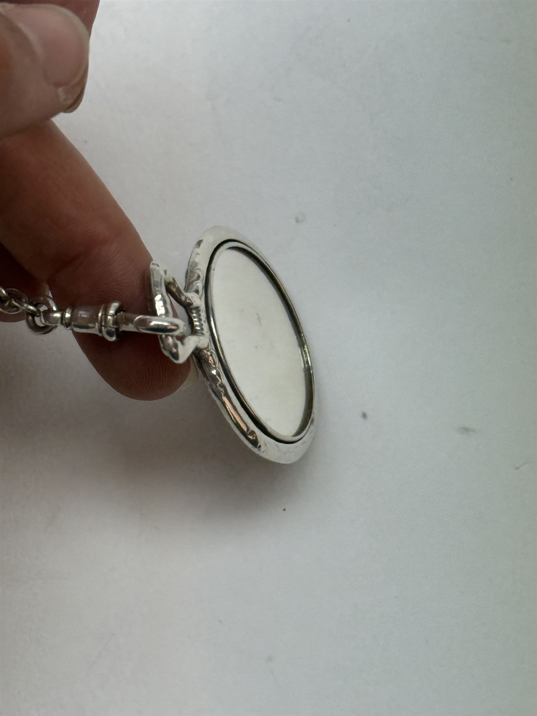 Victorian and later silver chatelaine, the shaped and foliate pierced clasp with embossed oval panel of a courting couple, hallmarked Levi & Salaman, Birmingham 1899, supporting six accessories on five chains: a circular mirror embossed with putti, hallmarked Henry Matthews, Birmingham 1911, pencil holder engraved with foliate scrolls, hallmarked Francis Webb, Birmingham 1914, conical scent bottle decorated with bamboo, (unmarked but testing as silver), aide memoire embossed with putti, hallmarked Samuel M Levi, Birmingham 1911, tape measure of compressed spherical form, hallmarked Henry Matthews, Birmingham 1899, and a purse with embossed putti, hallmarked Birmingham 1909, makers mark worn and indistinct, at longest point L31cm

