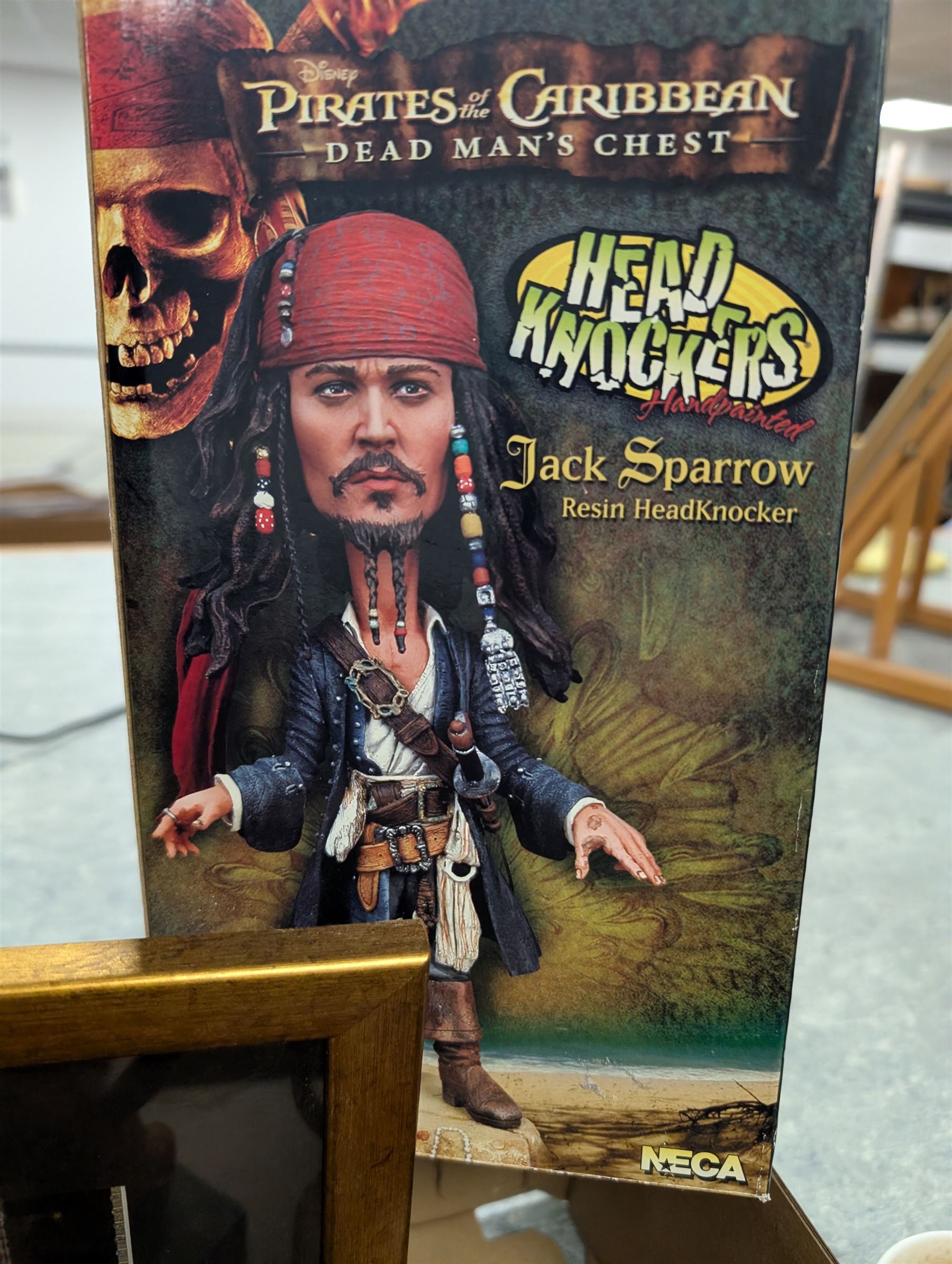 Collection of Disney and similar figures and memorabilia, including Pirates of the Caribbean Capt Jack Sparrow talking figure and NECA toys Jack Sparrow Head Knocker, three Disney showcase figures, Kermit the Frog framed film cell and Tomb Raider figure