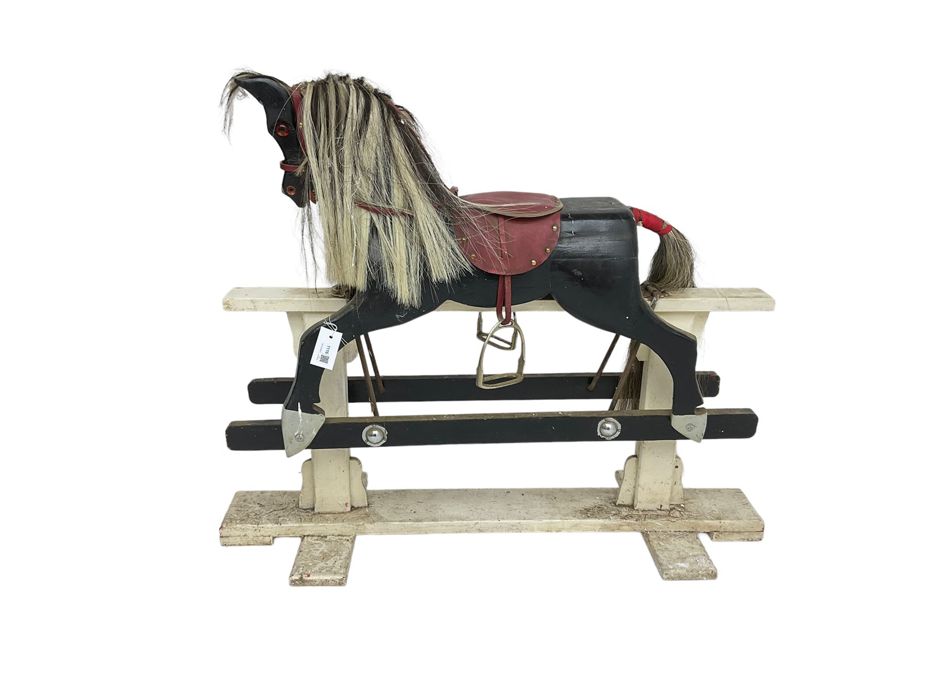 20th century black painted rocking horse on white painted trestle base, fitted with saddle and stirrups 