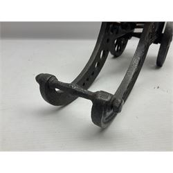 Victorian cast-iron and steel signal cannon, approximately half-inch bore, with 23cm ringed barrel and cylindrical trunnions, on a cast iron carriage with two twelve-spoked wheels and guilloche pierced swept back support, L43cm overall