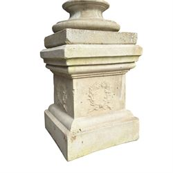 Pair of weathered composite stone campana urns on pedestals, the flared egg-and-dart rim over a tapering body with fruiting grapevine decoration in relief, over gadrooned underbelly, the rectangular pedestals moulded with floral garlands, planted
