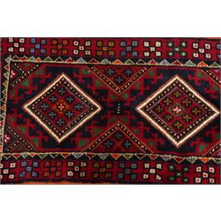Two hand-knotted rugs, comprising Persian runner and Turkoman prayer rug, Persian hand-knotted runner, red and dark navy ground with four diamond medallions and geometric motifs, enclosed by multicoloured geometric border, striped kilim ends with fringes, H244cm, W58cm; Turkoman hand-knotted prayer rug, ivory mihrab field decorated with repeating stylised geometric motifs, enclosed by multiple geometric borders in madder red and brown, with fringed ends, H150cm, W93cm