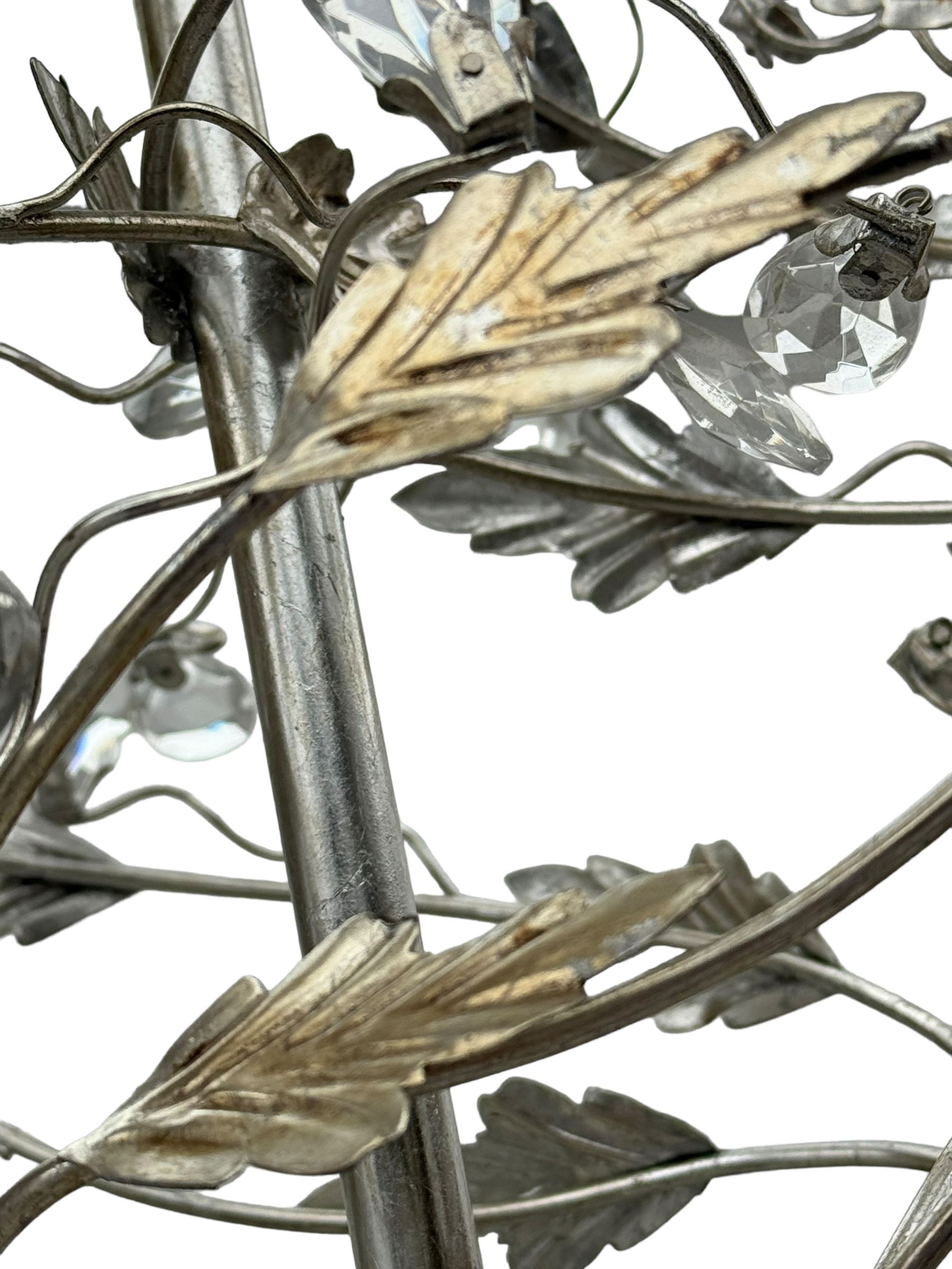 India Jane - silver finish metal chandelier, modelled with scrolling vines and leaves, embellished with faceted glass drops, fitted with six candle sconces, and wired for electricity