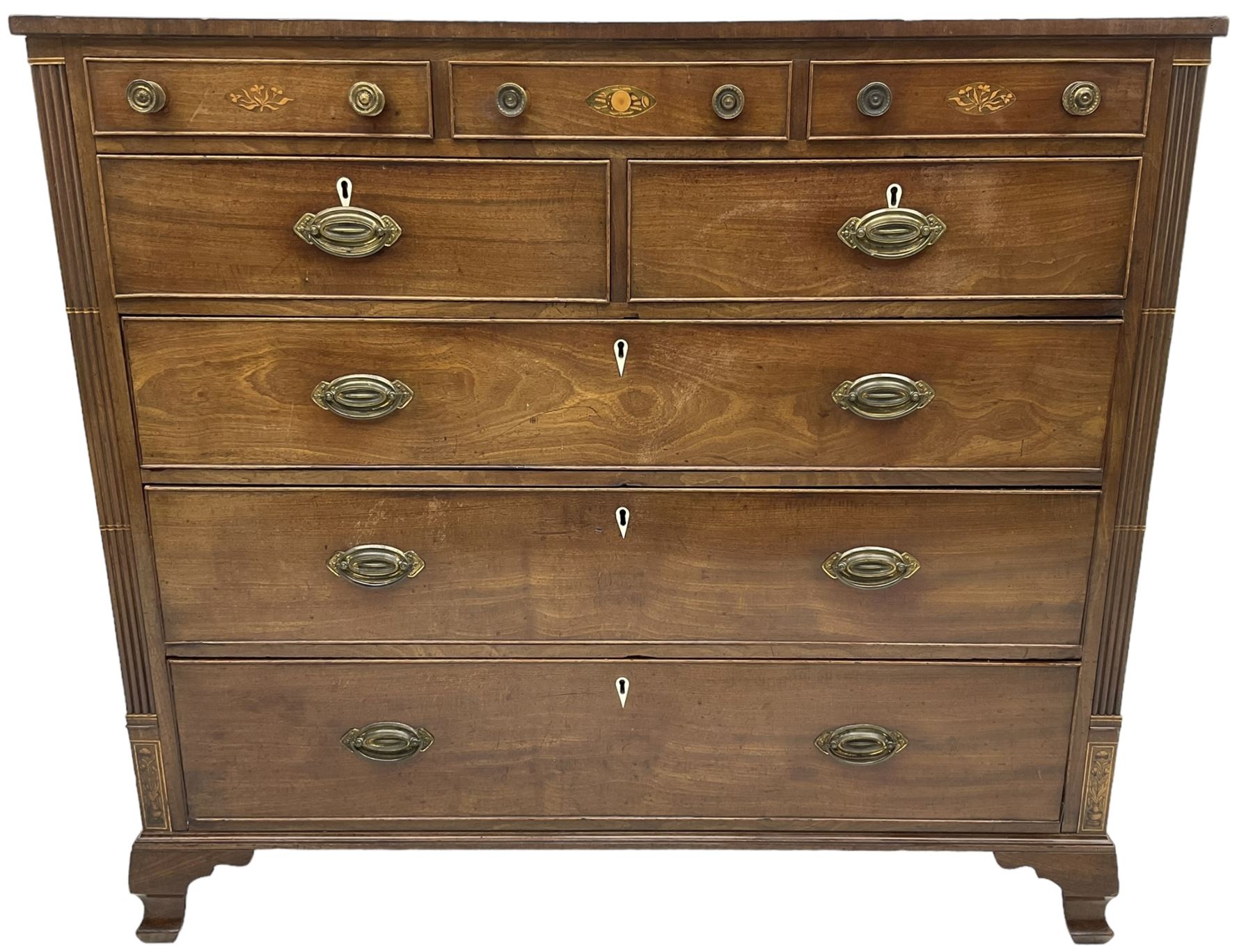 Early 19th century mahogany chest, three shallow frieze drawers over two short and three long cock-beaded drawers, canted corners with reeded moulded square columns, on ogee bracket feet