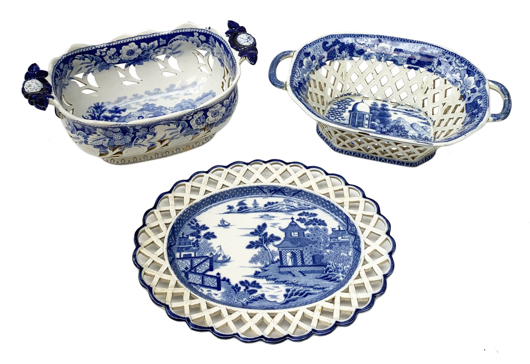 Mid 19th century blue and white transfer printed pearlware reticulated chestnut basket, of oval form with twin handles, decorated to the interior with figures before a classical temple within a garden setting, including handles W26cm, together with a mid 19th century blue and white transfer printed pearlware stand with reticulated edge, decorated with a Willow Pattern, L25cm, and a John and William Ridgeway blue and white transfer printed twin handled pierced basket, decorated with a pastoral scene containing figures at work, with printed mark beneath, including handles L25cm