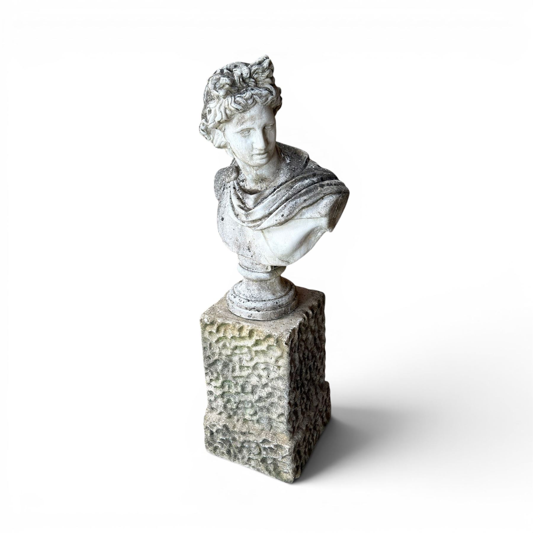 Roman Neoclassical style cast stone bust, weathered finish, raised on textured stone plinth of tapering form