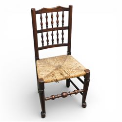 Set of five 19th century elm spindle back chairs, with shaped crest rails above double rows of turned spindles, rush seats, turned legs joined by stretchers supported on turned pad feet