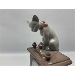 Lladro figure, Bedtime, modelled as a young girl reaching for her pet cat upon grandfather clock, sculpted by Vincente Martinez, with original box, no 5347, year issued 1986, year retired 1998, H28cm