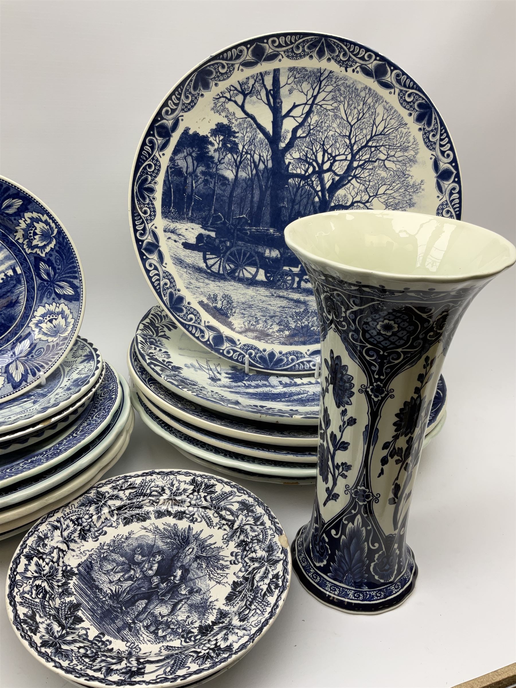 A large collection of modern transfer printed Delft ware, to include large baluster vase, H42cm, two jars and covers, largest H40cm, pair of tapering cylindrical vases, H31cm, and a number of plates of various size and design. 