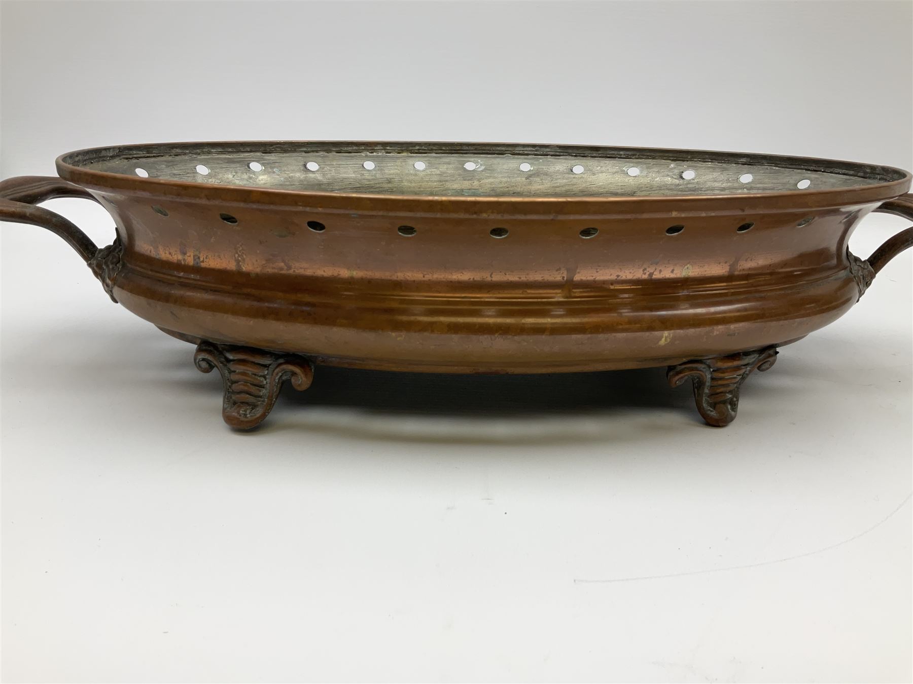 Agricultural copper corn funnel, H32.5cm, another similar copper funnel and copper warming platter of oval form, with twin handles on four supports, with removeable warming plate, L49cm