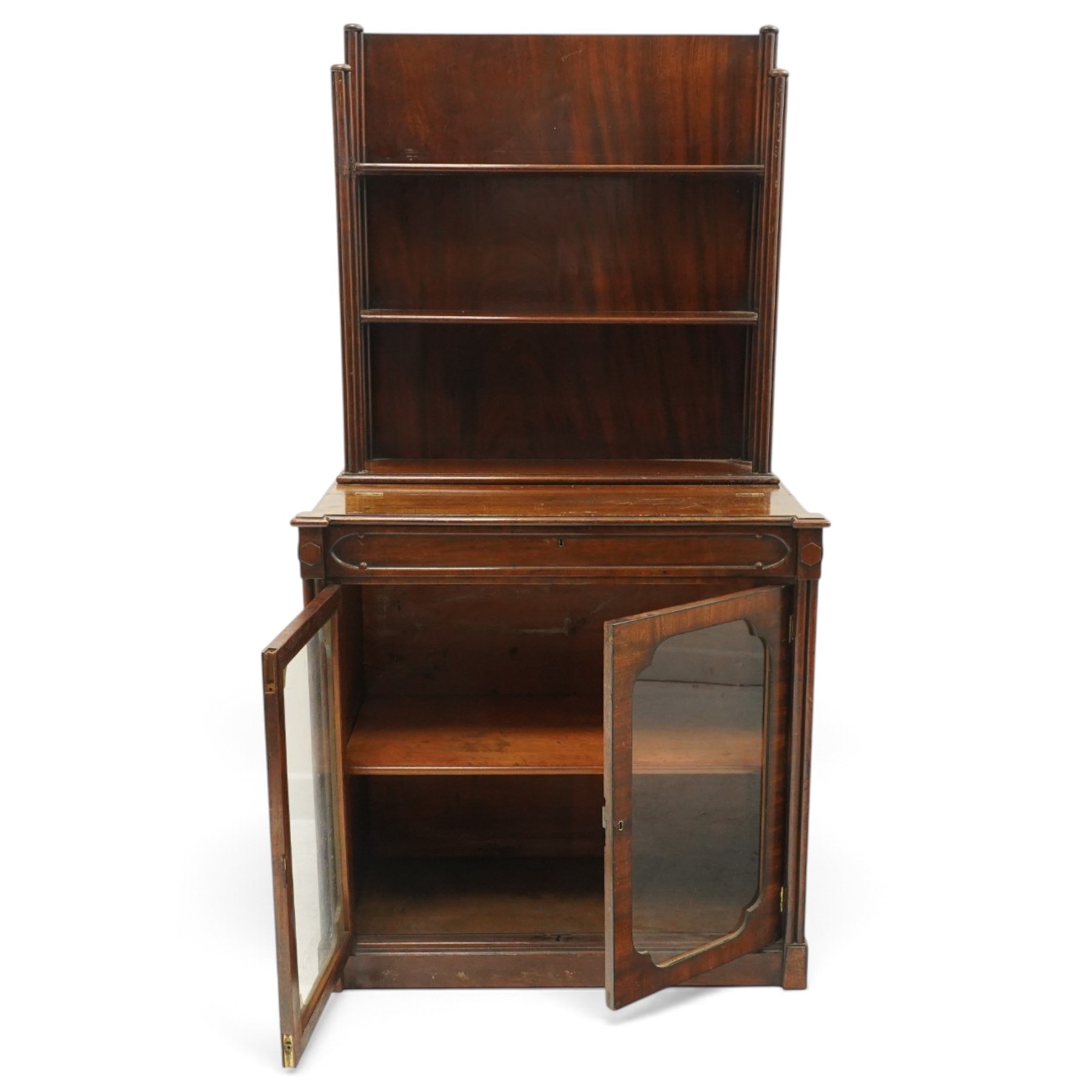 Late 19th century Gothic Inspired secretaire-chiffonier, the raised superstructure with two open shelves and cluster-column uprights, the base fitted with hinged top over secretaire drawer with hinged slope writing surface and pen-rest compartments, over a twin glazed doors enclosing single shelf, the flanking cluster-columns on skirted base