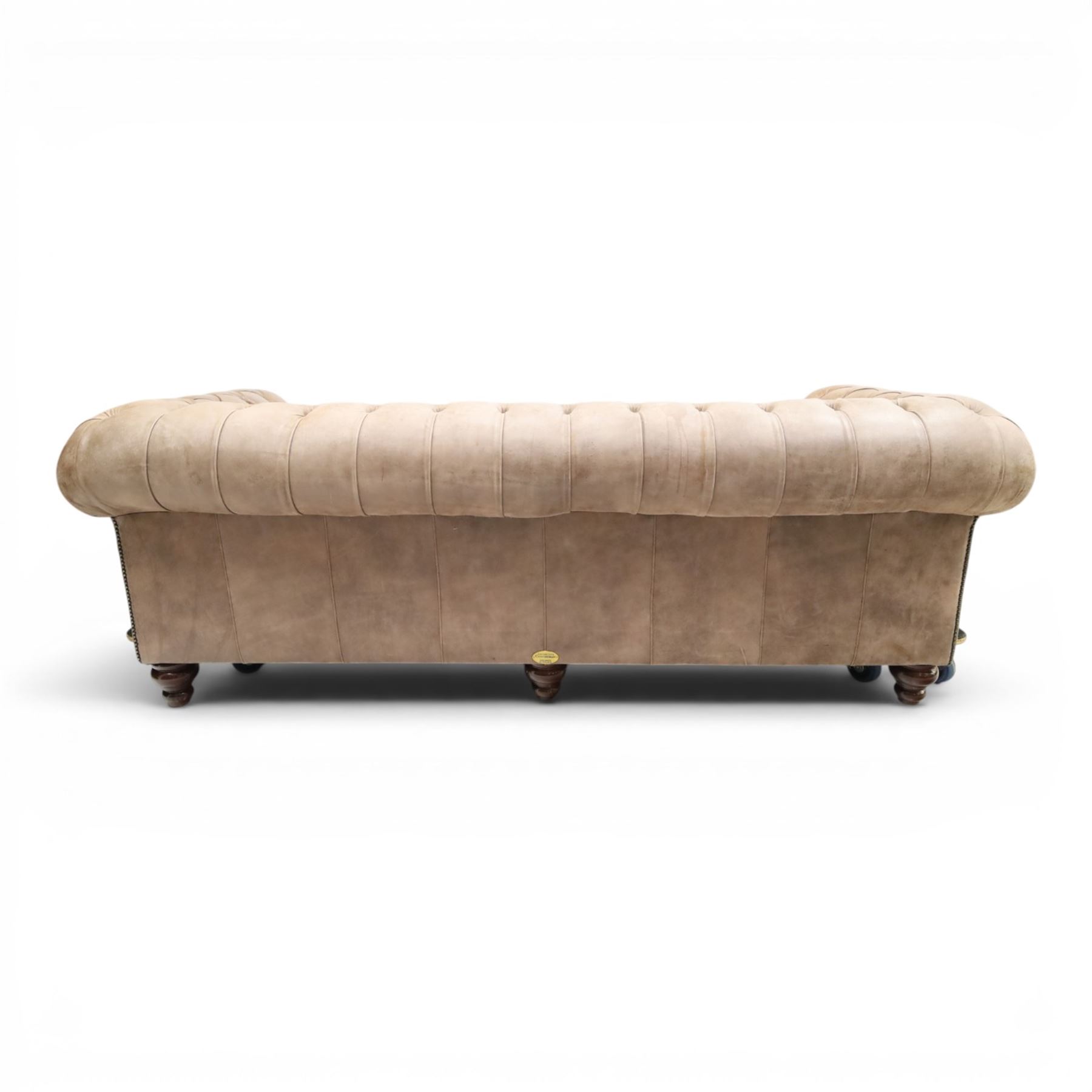 Distinctive Chesterfield - Chesterfield upholstered in taupe leather, deep button back and arms, loose seat cushions, raised on dark stained supports 