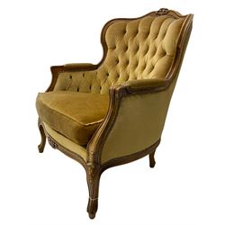 French style beech framed armchair, shaped back carved with flower heads, upholstered in buttoned fabric, cabriole supports 