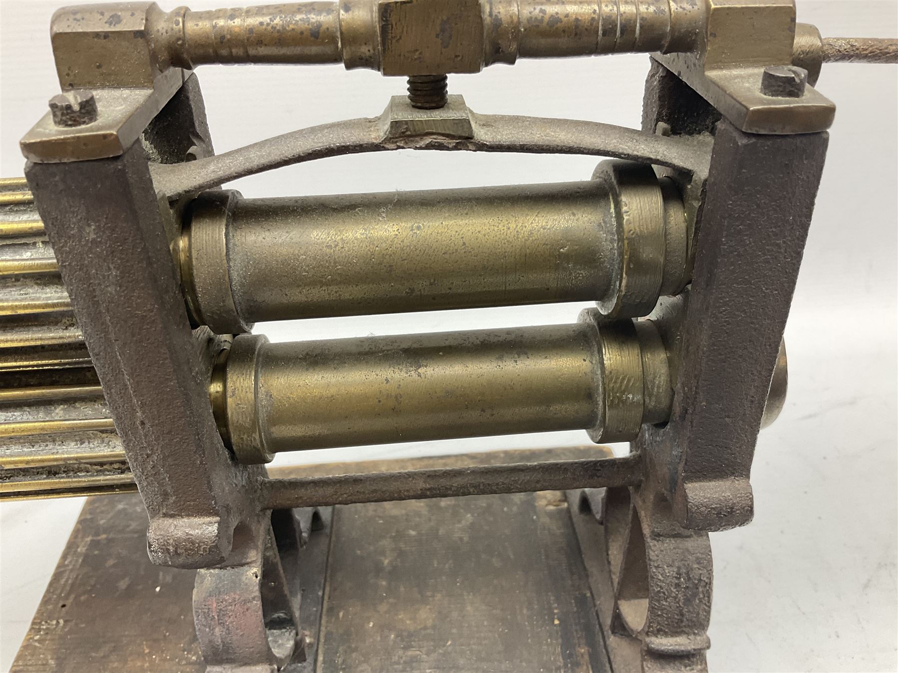 Victorian cuff and collar tabletop mangle, the ribbed brass rollers in a cast iron frame mounted on a wooden base