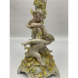 Dresden style candelabra, the central stem bordered by three branches, decorated with cherubs and yellow roses, H48cm