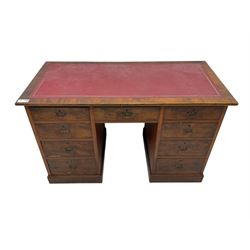 Late 19th to early 20th century walnut pedestal desk, rectangular top inset with red tooled leather writing surface, over a central frieze drawer flanked by two pedestals, each fitted with four graduated drawers with brass escutcheons and drop handles, the whole raised on a plinth base